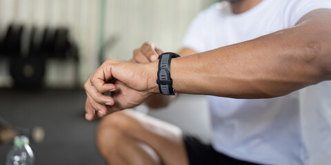 Fitness Tracking. Man checking smartwatch while resting after workout.