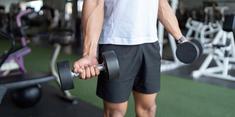 Dumbbell Workout. Man lifting weights in gym for strength training.