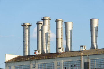 Pipes of thermal power plant on a town. Industrial zone in the city. Producing electrical energy concept.  System of electricity supply.