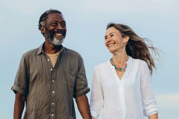 Portrait of a satisfied multiethnic couple in their 50s holding hands