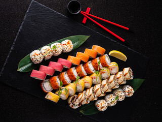 A colorful array of sushi rolls showcased on a black background, inviting a culinary journey