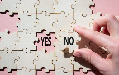 Yes or No symbol. Concept word Yes or No on wooden puzzle. Businessman hand. Beautiful pink...