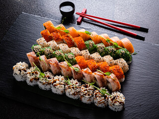 A beautiful array of colorful sushi delights artfully arranged on a black slate platter