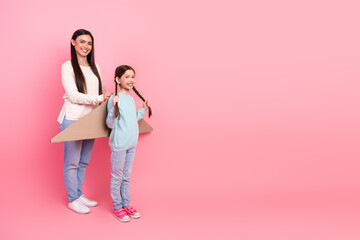 Mother and daughter bonding together with imagination on a playful day against a vibrant pink background