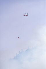 Helicopter Extinguishing Forest Fire Smoke Over Trees in Squamish, BC, Canada