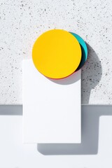 Yellow and Teal Circles on White Card Against Textured Background