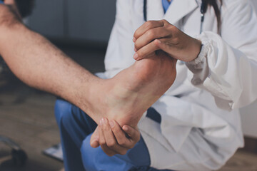 Fototapeta premium Physical therapist teaching a patient how to do exercises for his knee pain
