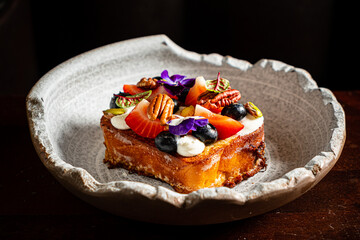 A delightful dessert features a cake adorned with fresh fruits, nuts, and edible flowers