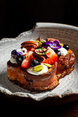 A stunning dessert topped with fruit, nuts, and flowers invites joy and indulgence