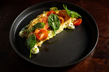 A stunning omelette with tomatoes, smoked salmon, and spinach showcases culinary artistry