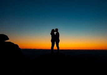 Silhouette of a couple kissing against a vibrant sunset sky