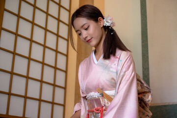 Young attractive Japanese woman in traditional kimono or yukata clothing in Japanese style house