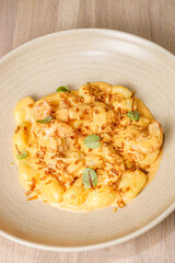 Savory gnocchi served with creamy sauce and crunchy toppings in a cozy dining setting