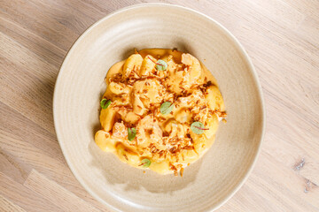 Delicious creamy pasta dish garnished with crispy toppings served in a bowl