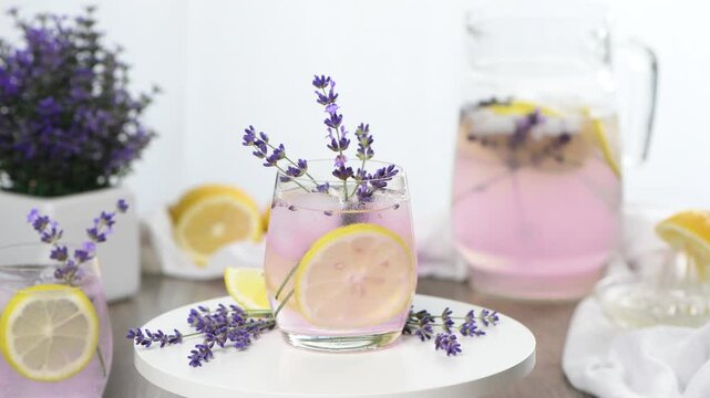 Glass with homemade lavender lemonade. Garnished with lemon slices and lavender sprigs. Horizontal video. Close-up. Circular motion, right to left