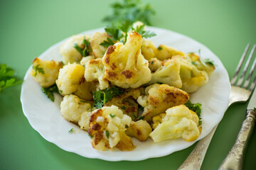 Rustic vegetable dish with cabbage and herbs on a green background