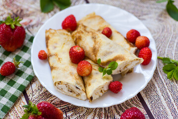 Appetizing pancakes with berries isolated on a wooden table