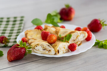 Pancakes with cottage cheese and strawberries for breakfast on a wooden table