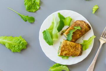 Healthy egg roll with greens on a white plate