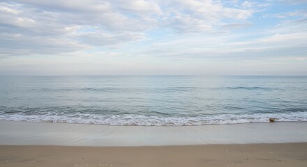 Calm Ocean Shoreline with Sandy Beach and Gentle Waves