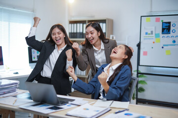 Three Asian businesswomen celebrating a successful project in a modern office, radiating joy and enthusiasm while fostering teamwork and unity