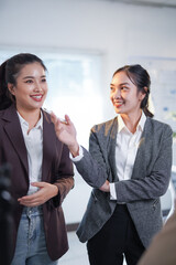 Two asian businesswomen discussing strategy during a meeting in a modern office, sharing ideas and collaborating on a project