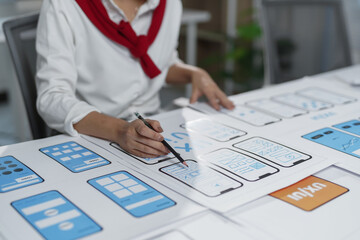 Web designer sketching a user experience user interface for a mobile application, creating a low...