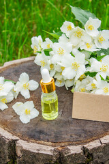 Jasmine essential oil in a glass bottle and jasmine flowers. Oils.