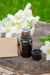 Jasmine essential oil in a glass bottle and jasmine flowers. Oils.