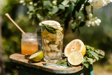 Refreshing citrus iced tea with mint and honey, captured in golden sunlight. Rustic and cozy summer beverage.