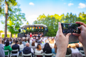 Person Filming an Outdoor Concert  with a Smartphone
