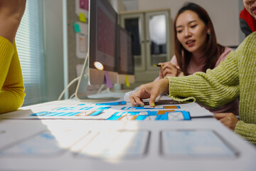 Fototapeta premium User experience designers collaborating on creating an innovative mobile app interface, sharing ideas and refining concepts in a dynamic office setting