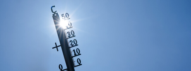 Hot weather, global climate change concept - Heat wave / Summer heat temperature celsius background banner long - Thermometer blue sky and sun rays