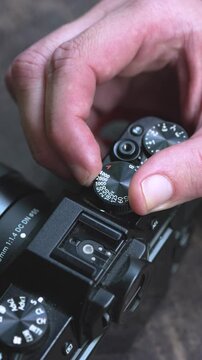 a person changes the shutter speed on his digital camera