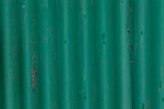 This is a green corrugated metal surface that prominently features vertical ridges and slight signs of wear. It is perfect for designs that require either industrial or natural elements