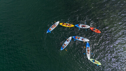 Aerial drone view of colorful canoes with anonymous children playing sports in the Mar Menor, Cartagena, Murcia Region.