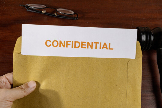 Confidential Legal Document Held by Hand with Gavel – Legal Confidentiality and Attorney-Client Privilege Concept