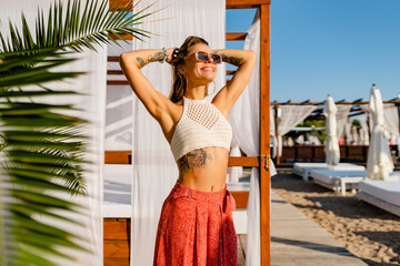 beautifil blond woman posing on summer beach in sunny weather