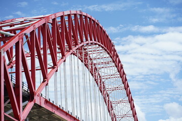 Majestic Red Steel Arch Bridge Against a Blue Sky