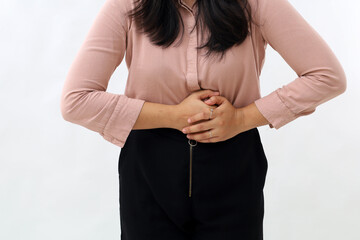 Close-up photo of woman's hand holding stomach, stomach ache concept, standing bent over, isolated...