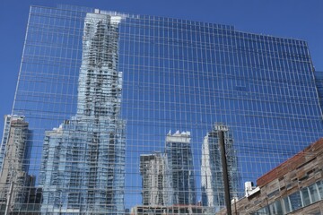 Modern city skyline reflected in a mirrored glass building