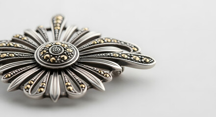 Close-up of an ornate Art D&eacute;co brooch with stylized sunburst design in silver and marcasite, isolated on a soft off-white background