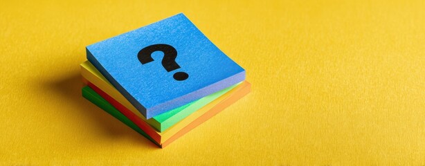 The stack of colorful sticky notes featuring a question mark on a yellow background.