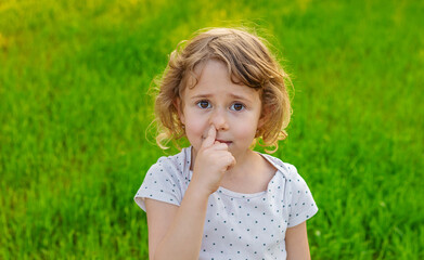 Child picking his nose. Selective focus.