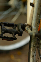 Here is a detailed and closeup view of a bicycle pedal that is firmly attached to the crankset, showcasing various mechanical components and notable wear from extensive usage over time