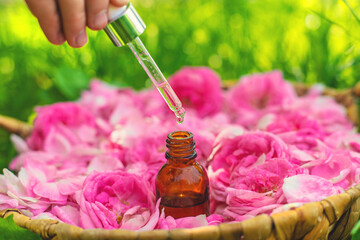 Rose essential oil in a bottle. Selective focus.