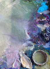 Close-up of an artist’s palette filled with mixed oil paints. Blue tone. Textured colors background. Horiszontal