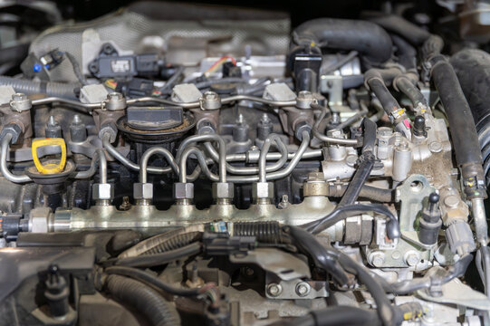 car engine repair,Close-up of a Modern Diesel Engine &ndash; Fuel Injection System and Hoses, modern diesel engine with a visible common rail fuel injection system, metal fuel lines, and a yellow oil 