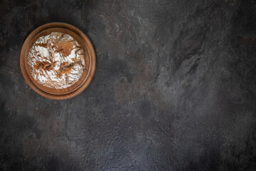 Artisan bread on wooden board with copy space, dark slate background