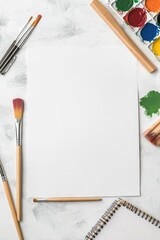 Blank watercolor paper surrounded by art supplies